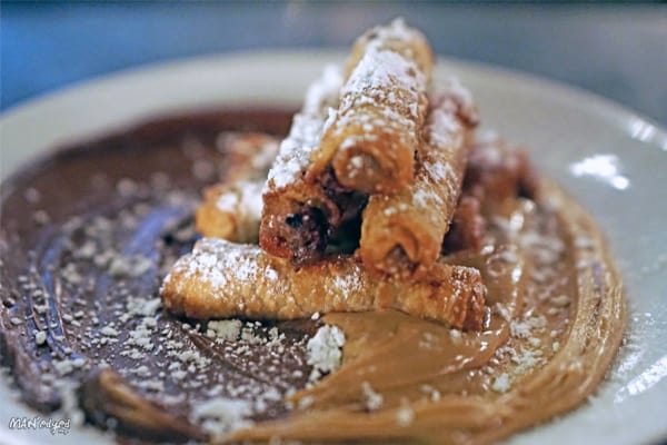 Cookie dough egg roll desert served on Nutella and Peanut Butter dessert in MAN'edged Magazine best foods to celebrate 420