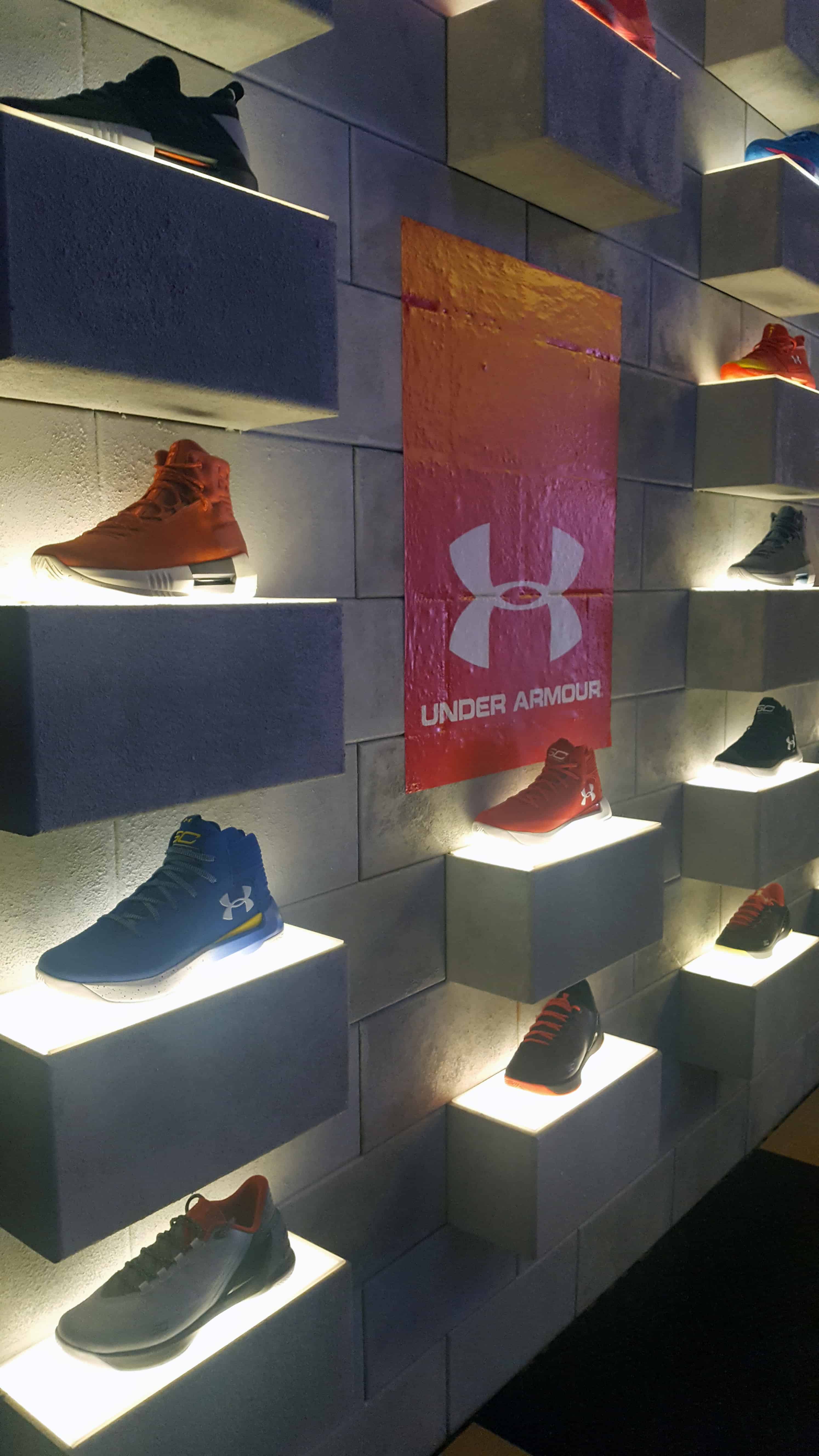 Under Armour sneakers displayed on wall