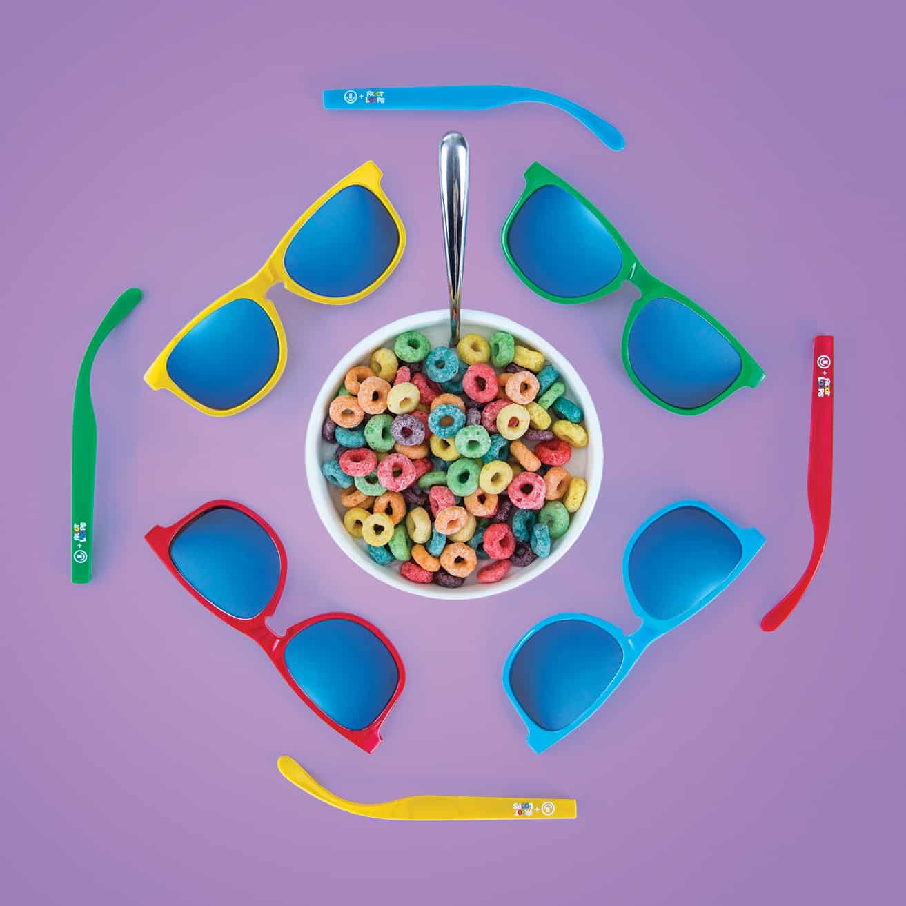 Multiple sunglasses frames and arms surrounding bowl of fruit loops