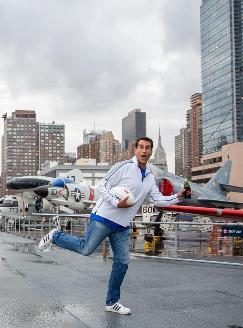 Ron Riggle with Dos Equis search for best college football fan standing on the Intrepid NYC