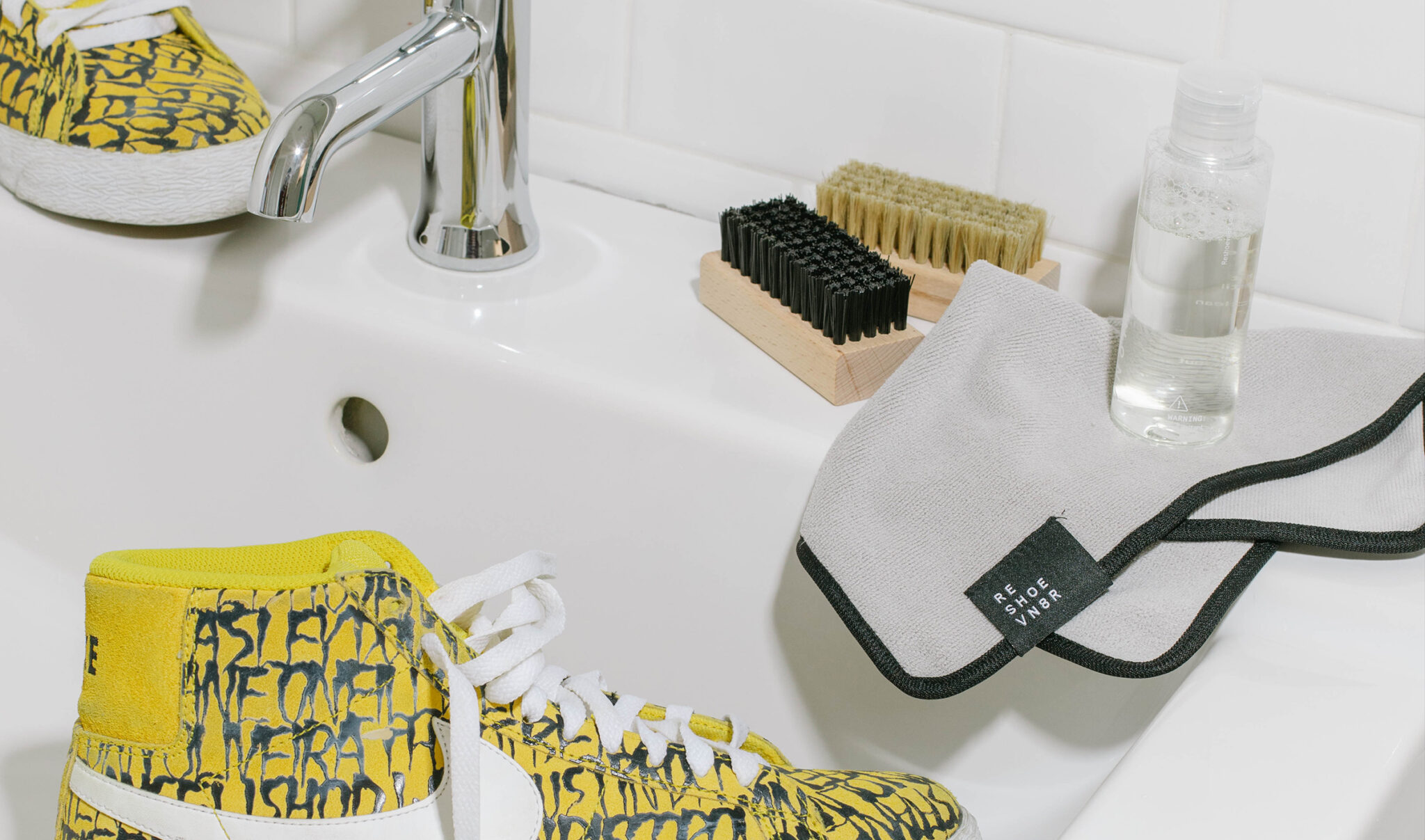 sneakers laying next to the best shoe care kit for sneakers