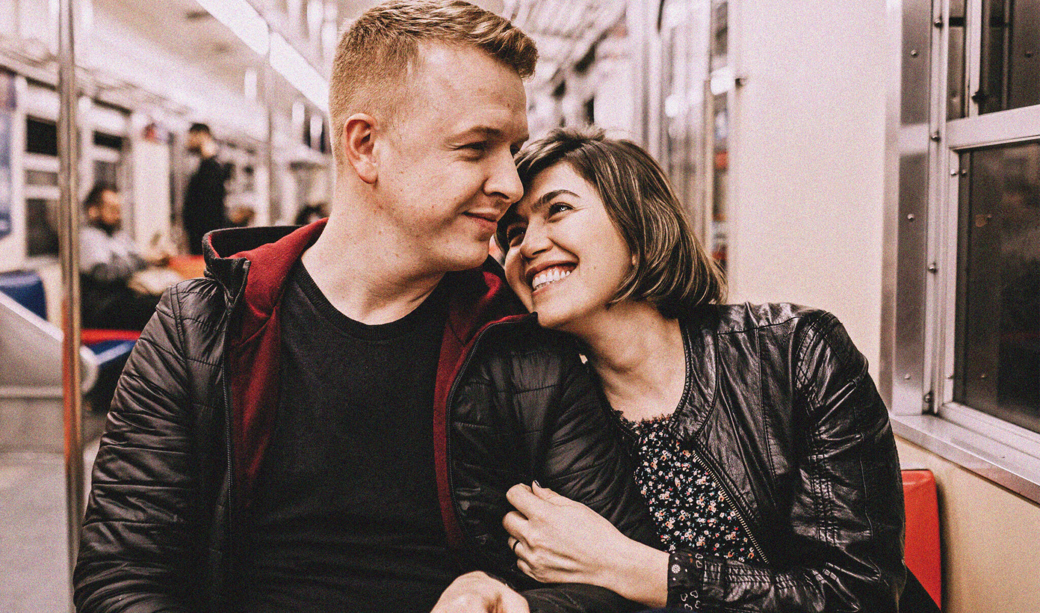 A couple on the train holding arms on a date featured in MAN'edged Magazine best dating advice for men 2020