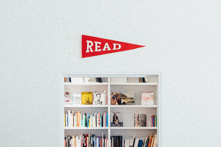 a sign above a filled book shelf that says read