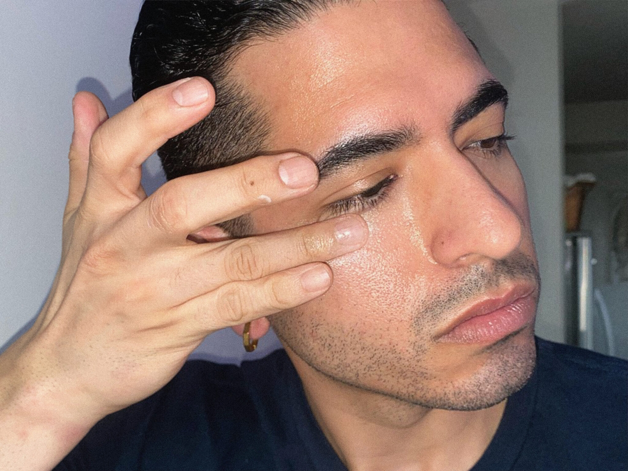 man applying under eye cream