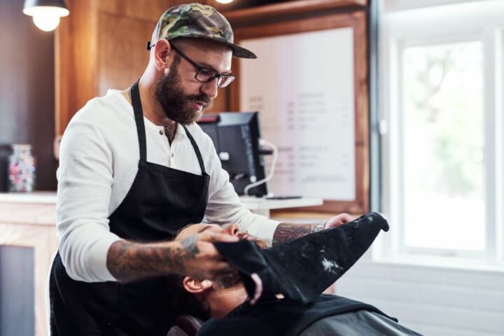 A barbershop employee working closely with a client to provide the ultimate experience of luxury and comfort.