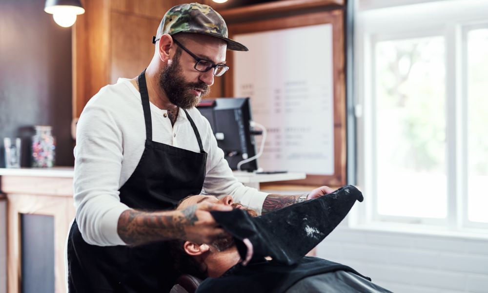 A barbershop employee working closely with a client to provide the ultimate experience of luxury and comfort.