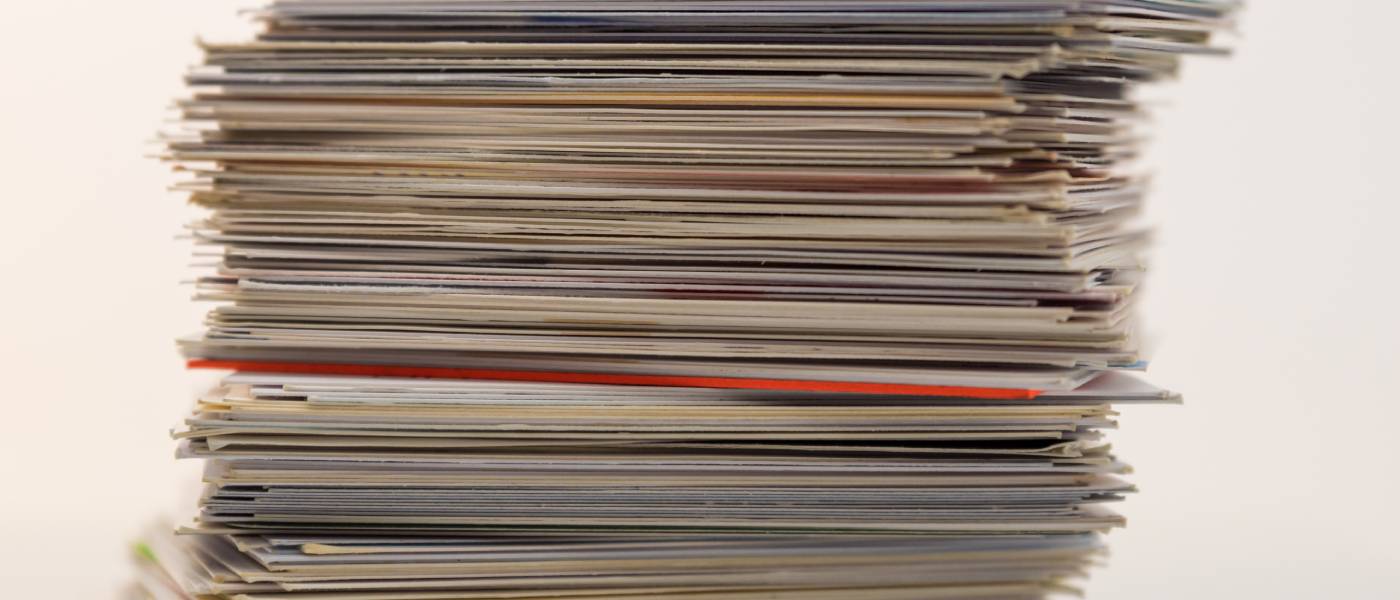 A stack of trading cards sitting on a table against a white background. Some are in casings and others are original format.