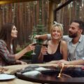 A group of friends gathered around an above-ground fire pit. They're socializing and enjoying beverages.