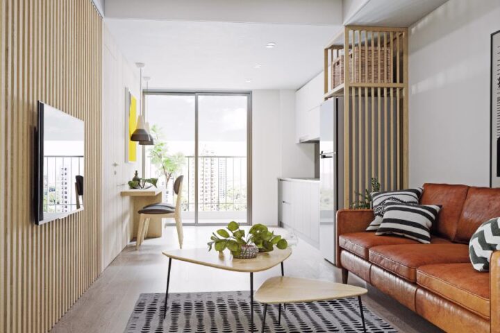 A small city apartment with modern interior design, such as wall paneling, an orange leather couch, and MCM coffee tables.